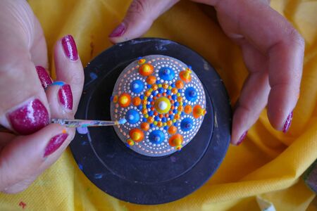Painting of a stone with the mandala technique during the holiday in Kythira, Greece