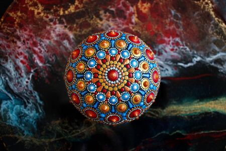 Beautiful hand painted mandala rock on black background