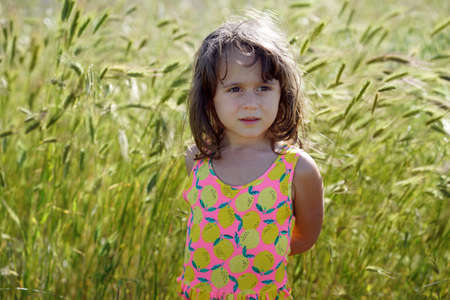 Portrait of an Italian little girl with a background of green spikes