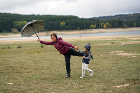 A little girl plays with her mother near Lake Cecita, in the Sila National Park in Calabria, Italyの写真素材