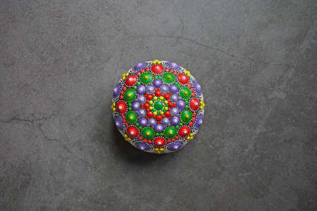 Beautiful colorful hand painted dot mandala on gray background, isolatedの写真素材