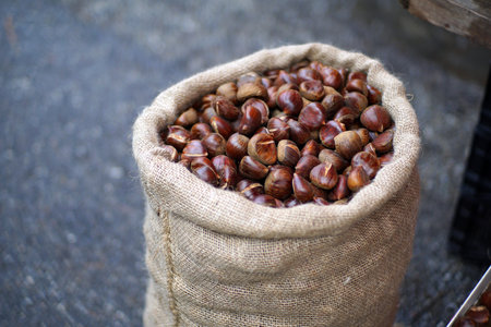 Chestnuts in a basket with autumn leavesの写真素材