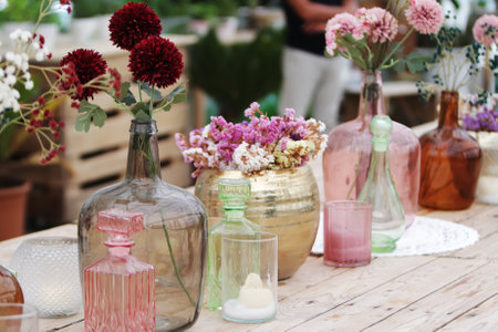Beautiful decoration with flowers and colorful glass vases, selective focusの写真素材