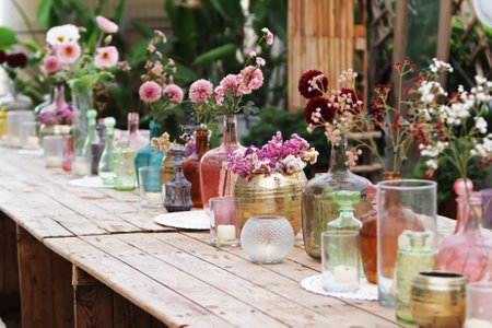 Beautiful decoration with flowers and colorful glass vases, selective focusの写真素材