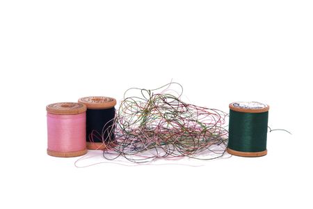 A Pile of Loose Thread and Spools on a White Background