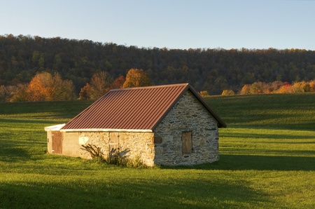 An old stone building surrounded by green during autumnの写真素材