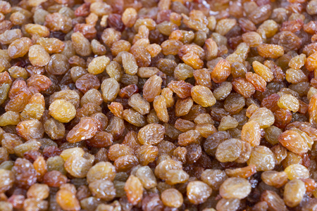Grape raisins background. Close up. Top view. Brown and yellow sweet dried grapes. Selective focus on center.の写真素材
