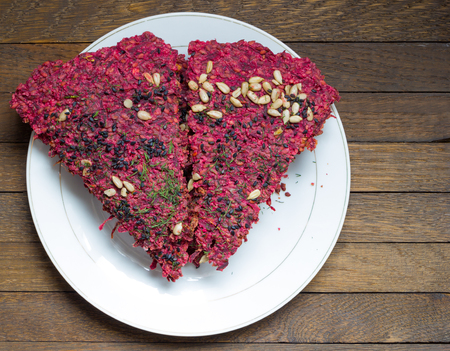 Dry beet vegan bread on white plate on wooden table with copy space. Top view. Close up. Healthy nutrition concept. Raw foods. Delicious natural snack, cooked by low baking in dehydrartor.の写真素材