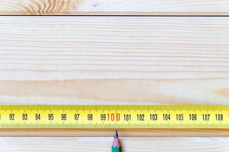 One hundred centimeters on measuring tape with copy space. The tip of a simple pencil indicates the...