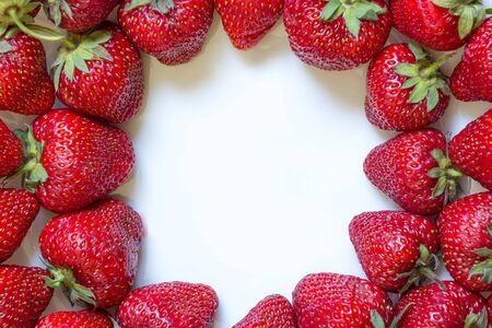 Frame from fresh strawberry with white copy space inside. Top view, Flat lay, Close-up. Place for custom text in middle. Raw fruits background. Delicious berries on white plate. Natural homegrown foodの写真素材