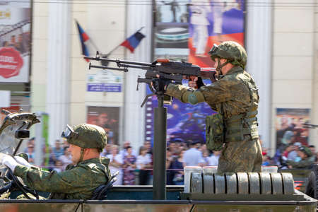 Donetsk, Donetsk People Republic, Ukraine, June 24,2020: A machine gunner on a military vehicle with a driver and a navigator on board move along the main street of the city during the Victory Parade.のeditorial素材
