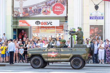 Donetsk, Donetsk People Republic, Ukraine - June 24, 2020: A military vehicle with a stationary machine gun and soldiers on board move along the main street of the city during the Victory Parade.のeditorial素材