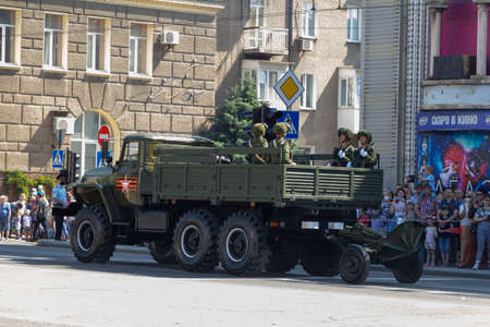 Donetsk, Donetsk People Republic, Ukraine, June 24, 2020: A convoy of military vehicles with Soviet artillery guns on a trailer moves along Artyom Street during the Victory Day parade in World War II.のeditorial素材