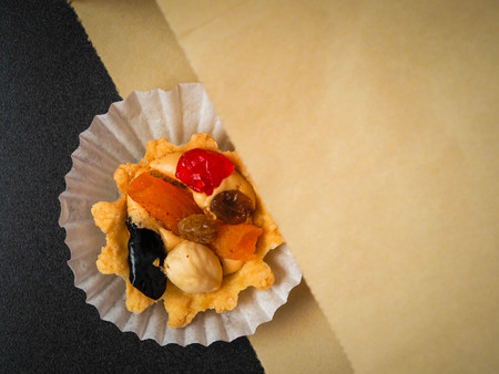 A tasty dessert home-made pastries in an ecological container a paper package on a black background.の写真素材