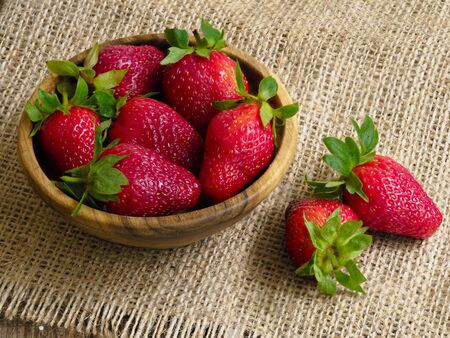 Garden strawberries plucked and placed in a wooden bowlの写真素材