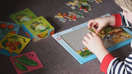 A small child puts together a puzzleの写真素材
