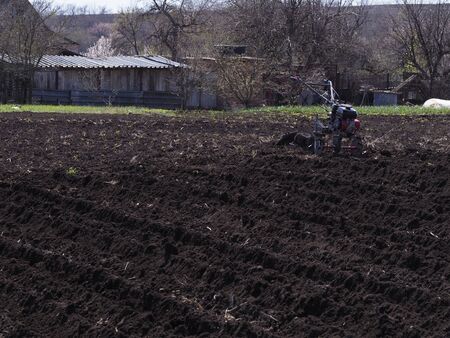 The farmer working with the cultivator. Agricultural industry.の写真素材