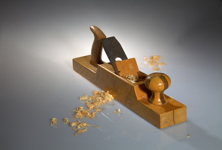 Close-up of an old wooden planer with wood chips on the foreground and background.の写真素材