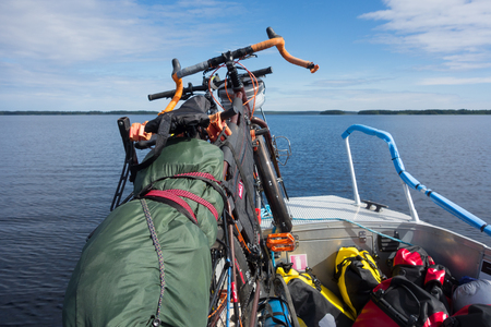 Taipalsaari, Finland â July 2, 2015: Two touring bikes tied securely to a fishing boat with colorful panniers on the boat floor by the lake Saimaa, Finland for crossing to the other side of the lake from Taipalsaari on 2 July 2015.のeditorial素材
