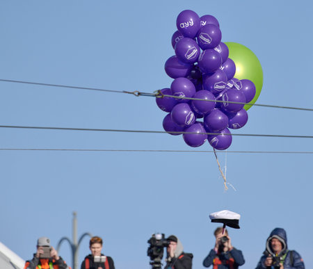Helsinki, Finland - April 30, 2019: Student cap flying supported by balloons to be place on Havis Amanda statue in the center of Helsinki as a highlight of the Finnish May day eve carnival with camera men and photographers on the background.のeditorial素材