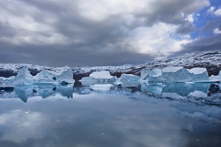 the coasts of greenland with giant floating icebergs and mountainsの写真素材