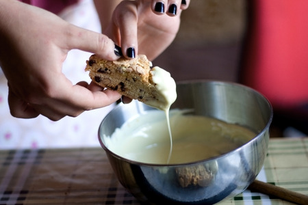 Dipping biscotti in white chocolate.の写真素材