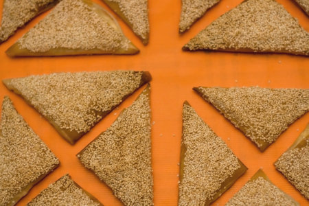 Puff pastry triangles, filled with cheese. Orange background.の写真素材