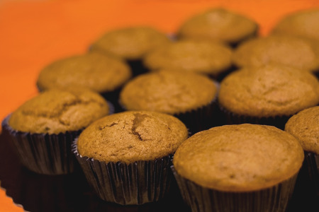 Pile of muffins, selective focus and orange background.の写真素材