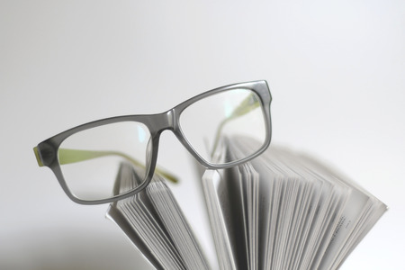 Eyeglasses on an open book. Focused on the glasses, shallow dof.