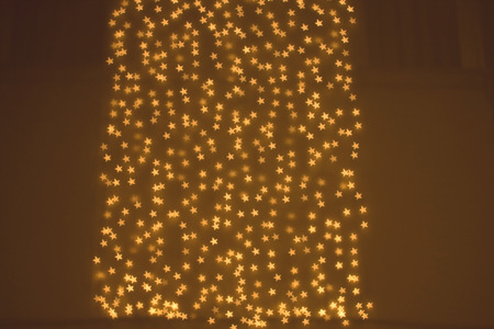 Shiny defocused background with bokeh lights shaped like little stars.