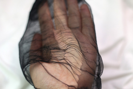 Hand holding ripped black tights. Selective focus.の写真素材