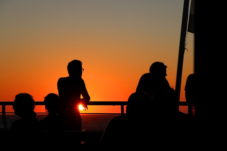People enjoying sunset on the ferry.