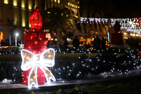 Lit candle on a big outdoor Christmas wreath at night. On Riva promenade in Split, Croatia. Selective focus.の写真素材