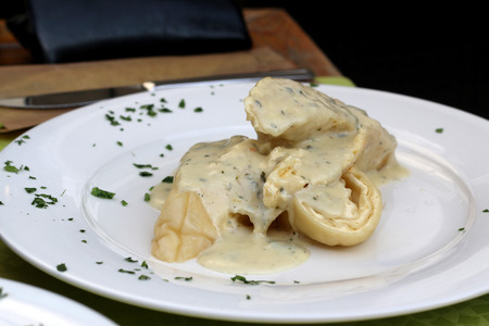 Traditional Slovenian meal called 'Strukelj' - rolled dumpling filled with cheese and creamy Gorgonzola cheese sauce. Selective focus.の写真素材