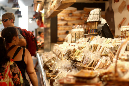 Barcelona, Spain - July 7, 2018: Visitors look at traditional desserts for sale at famous La Boqueria market in Barcelona, Spain.のeditorial素材
