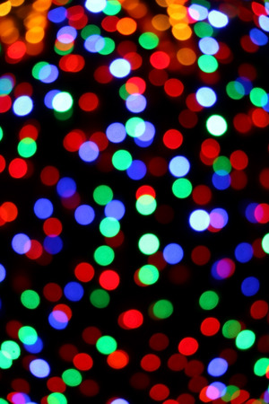 Festive Christmas background with colorful defocused bokeh lights.の写真素材