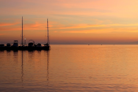 Boats in a harbor at sunset with beautiful colorful sky.の写真素材