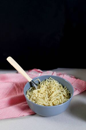 Bowls of lemony pasta. Selective focus, dark background.の写真素材