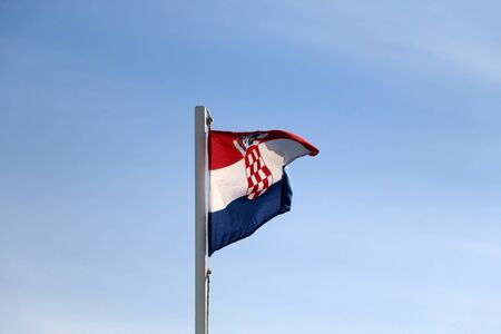 Flag of Croatia, blowing in the wind. Clear blue sky in the background.の写真素材