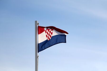Flag of Croatia, blowing in the wind. Clear blue sky in the background.の写真素材