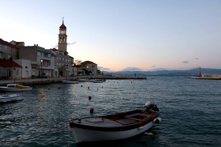 Small fishing boat in the port of Sutivan, town on island Brac, Croatia during dusk. Selective focus.の写真素材
