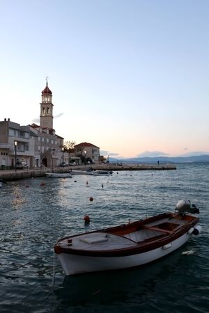 Small fishing boat in the port of Sutivan, town on island Brac, Croatia during dusk. Selective focus.の写真素材