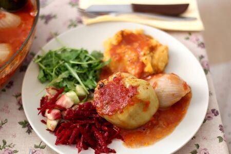 Pepper, onion and zucchini stuffed with various vegetables and roasted with tomato sauce, served on a table. Selective focus.の写真素材