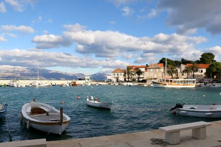Small fishing boats and traditional Mediterranean houses on promenade in Sutivan, island Brac, Croatia.の写真素材