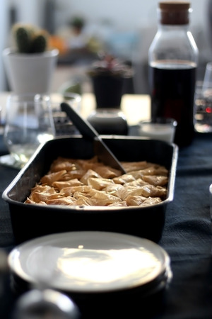Pan of baklava on a table with coffee and wine. Baklava is traditonal Turkish pastry desset. Selective focus, moody lighting.の写真素材