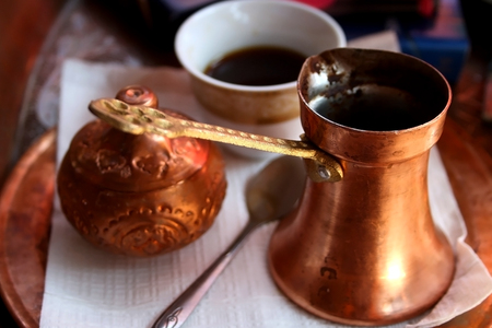 Turkish coffee served in a traditional copper pot. Selective focus.の写真素材
