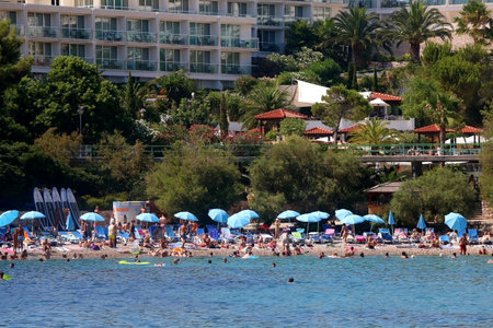 Hvar, Croatia - August 7, 2015: Tourists and locals enjoying sunny summer day on Bonj beach in front of hotel Amfora in town Hvar, on island Hvar, Croatia. Hvar is popular summer travel destination.のeditorial素材