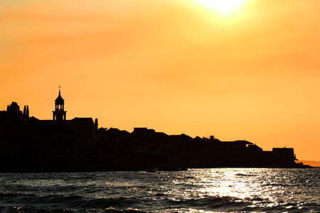 Sunset over Sutivan, small town on island Brac, Croatia. Silhouette view of landmark baroque bell tower.の写真素材