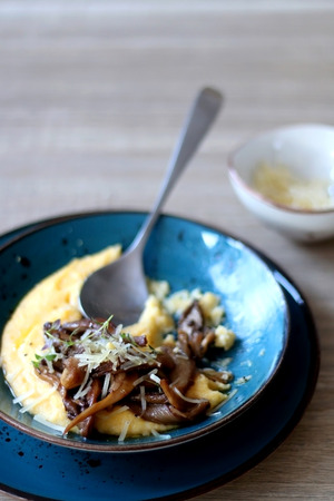 Fried mushrooms and polenta with cheese and herbs. Selective focus.の写真素材