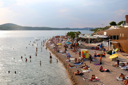 Sibenik, Croatia - August 20, 2018: Crowd enjoying sunny summer day on Banj beach in Sibenik, Croatia. Sibenik is popular summer travel destination.のeditorial素材